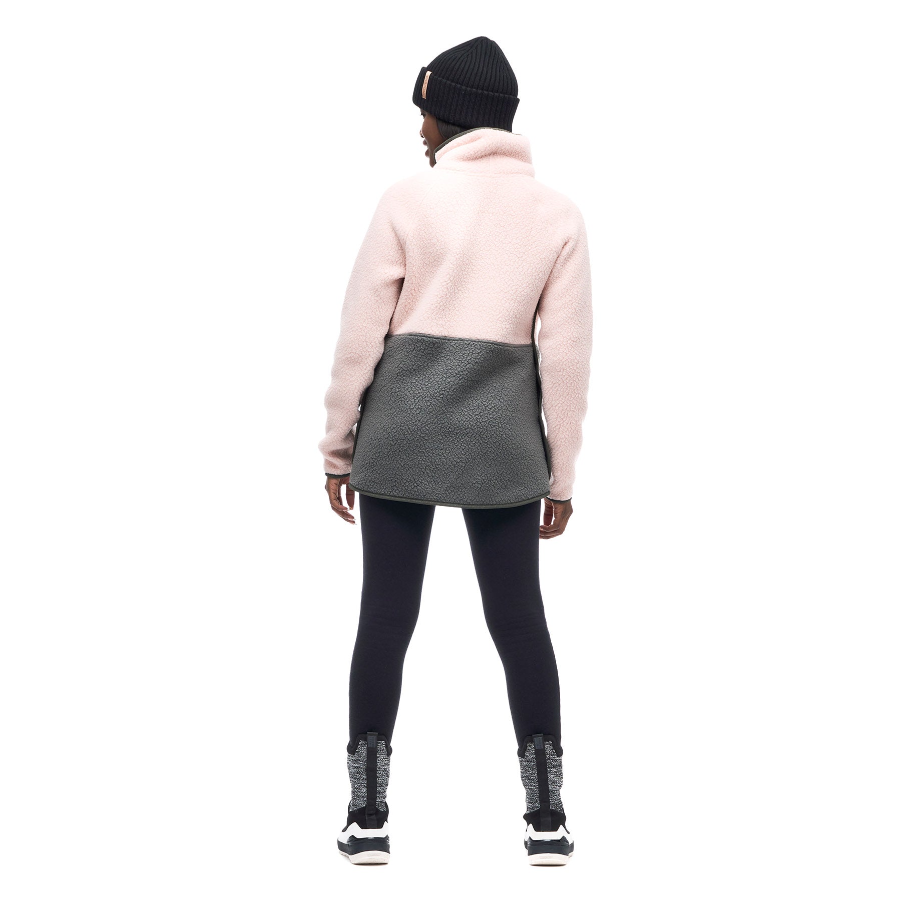 Image featuring the back of a female model wearing a black beanie and the Indyeva Pecora pull over sweater in Himalaya Ivy