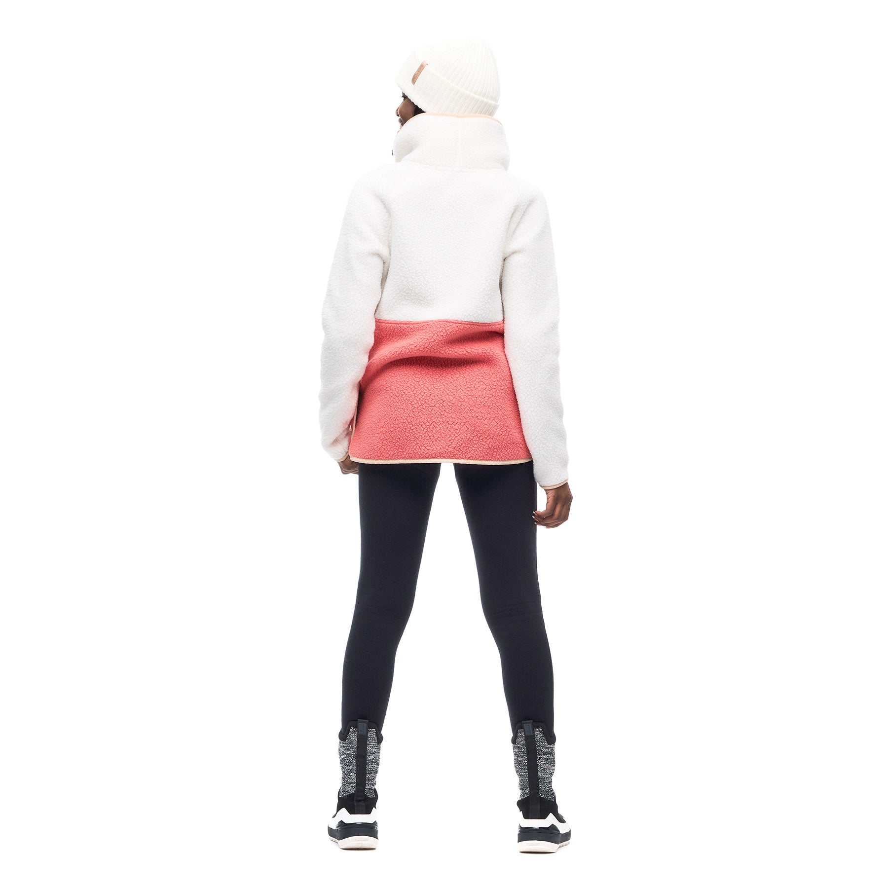 Hero image featuring the back of a model wearing the Indyeva Pecora Pullover Sweater in Ecume Lili with black leggings and a white beanie.
