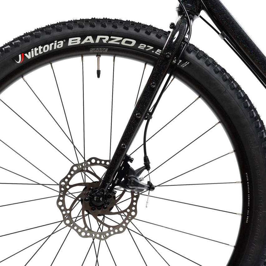 Image featuring the front tire, brake, and fork of the State 4130 All-Road bike in black.