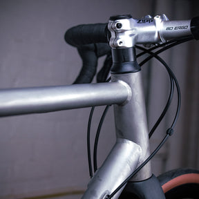 Image features the front frame, handlebars, and cables on the BSC Ti road bike