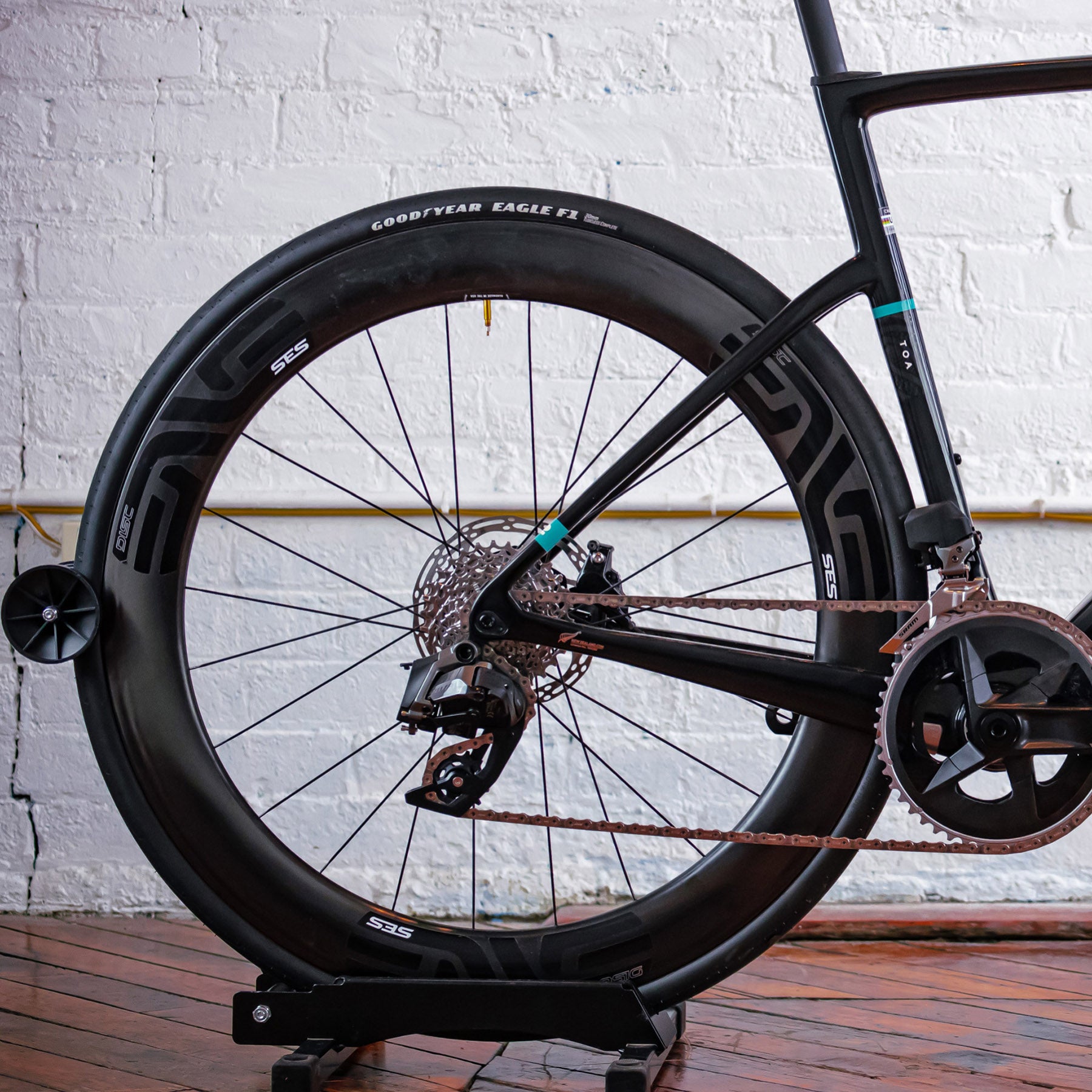 Image features the back tire, pedal, gears, and brake of the Chapter 2 TOA bike