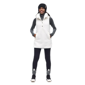 Hero image featuring a front facing photo of a model wearing the Indyeva Pecora Tunic in white with black leggings and a black beanie.