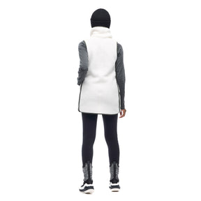 Image features a back angle photo of a model wearing the Indyeva Pecora Tunic in white with black leggings and a black beanie.