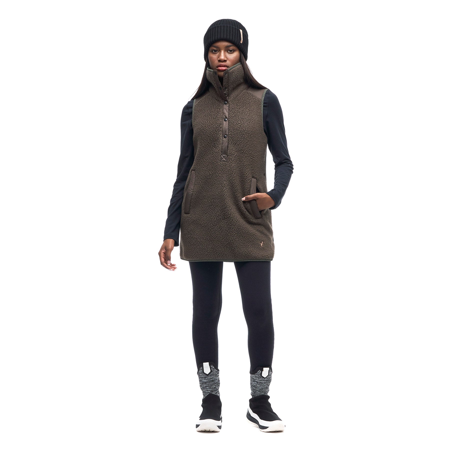 Hero image featuring a front facing photo of a model wearing the Indyeva Pecora Tunic in mocha with black leggings and a black beanie.