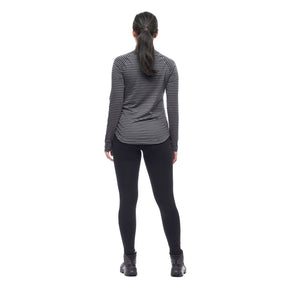 Image features a back facing model wearing the Indyeva Riga II long sleeve in pine ivy with black leggings and black shoes.