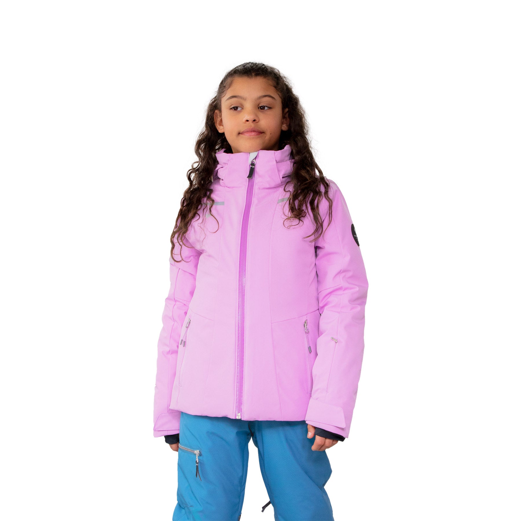 Hero image featuring a female model wearing the Obermeyer Leia Jacket in fairytale light purple with blue ski pants.