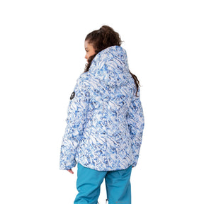Hero image featuring the back of a female model wearing the Obermeyer Leia Jacket in verglas white with blue highlights and light blue ski pants.