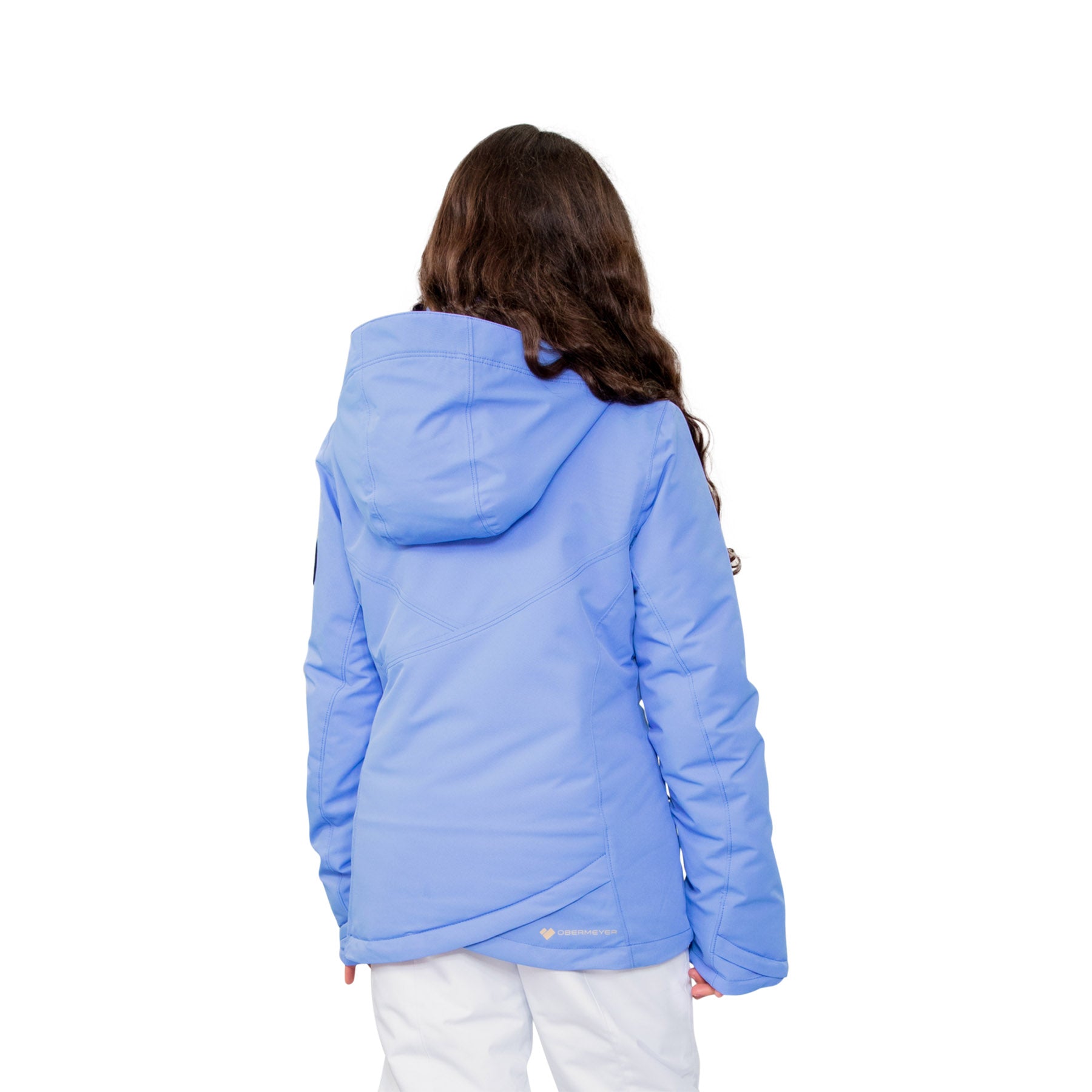 Image features the back of a female model wearing the Obermeyer girls Rylee Jacket in Vinca light purple and white ski pants.
