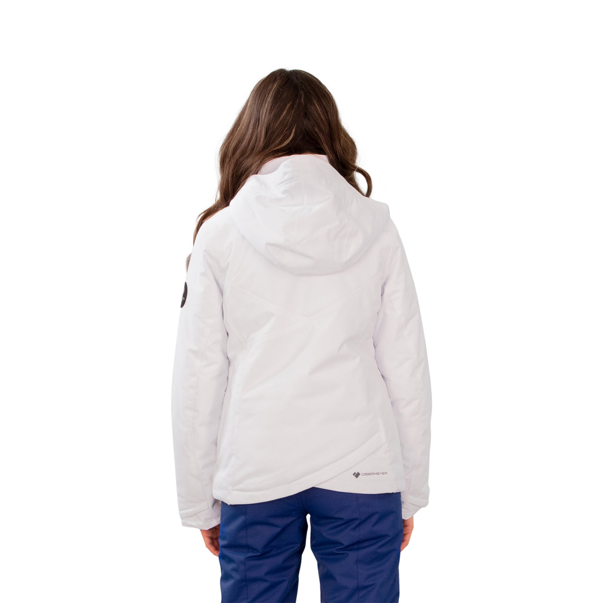Image features the back of a female model wearing the Obermeyer Rylee Jacket in white with blue ski pants.