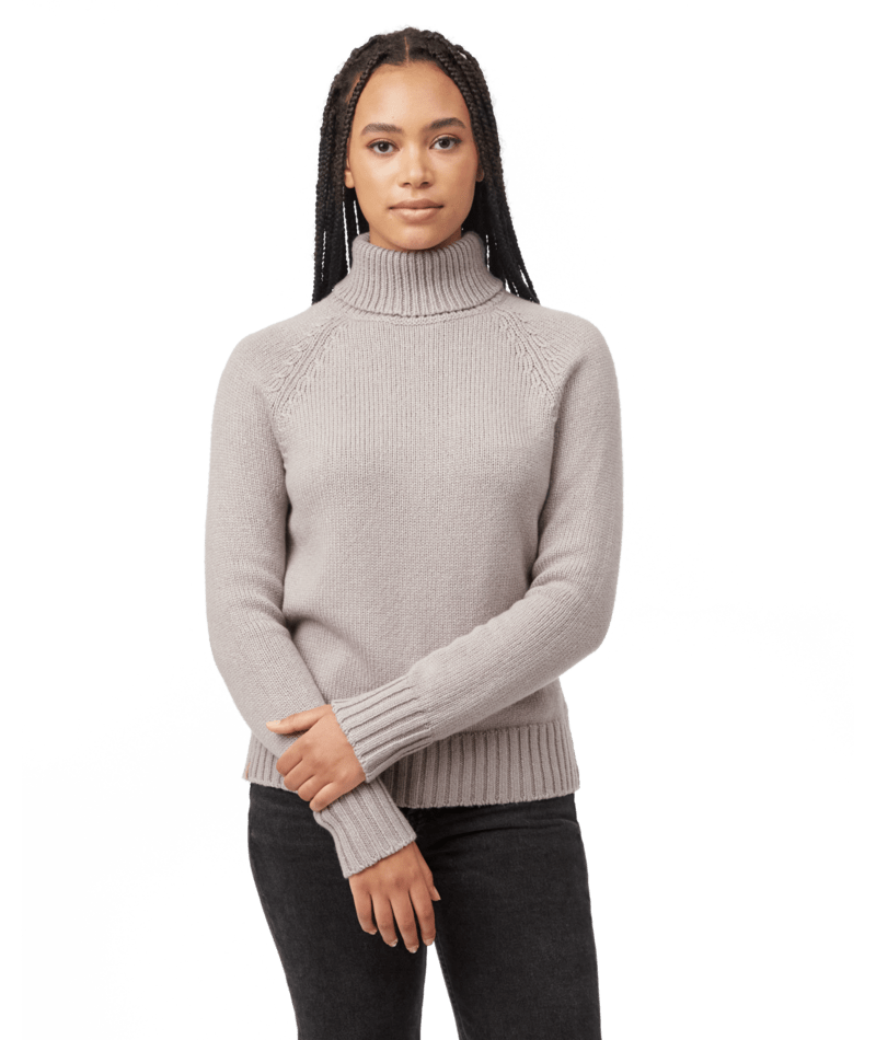 Hero image featuring a female model wearing black jeans and the Ten Tree Highline wool sweater in light grey.